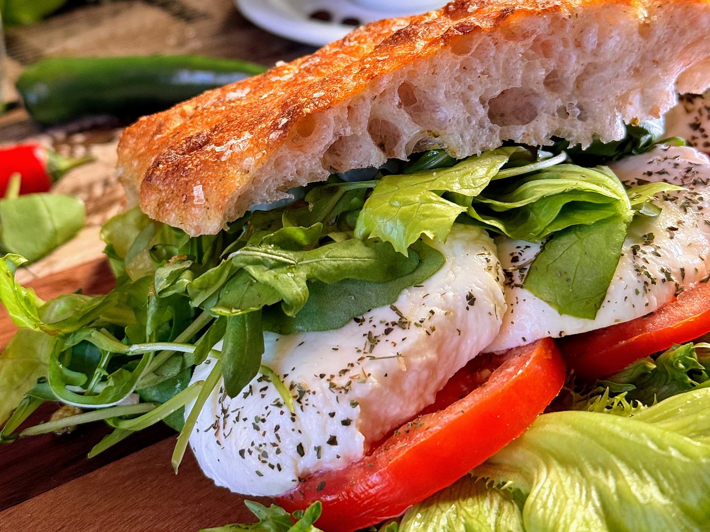Focacciasmörgås med mozzarella, tomat och ruccola på träbräda