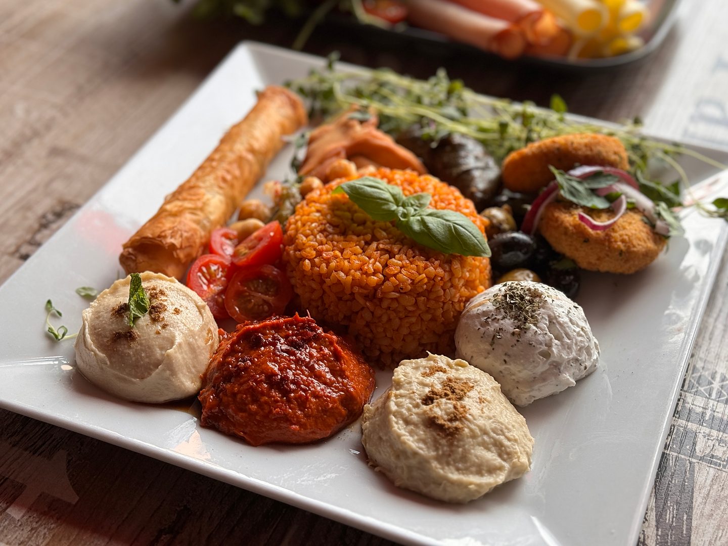 Mezetallrik med hummus, paprikaröra, labneh, bulgur, vinbladsdolmar och ostrulle